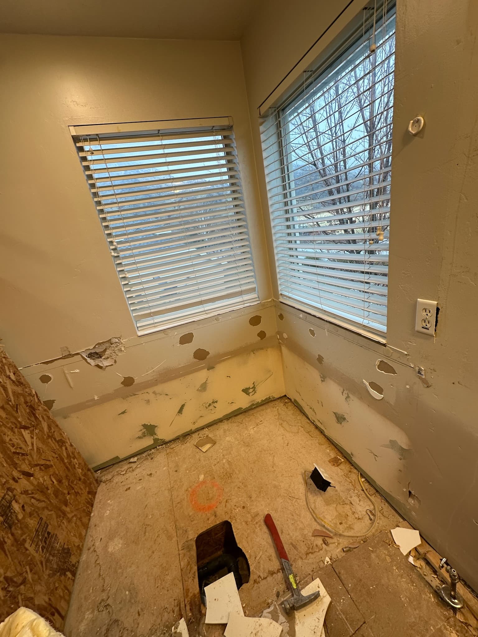 Bathroom mid-demo with debris and tools